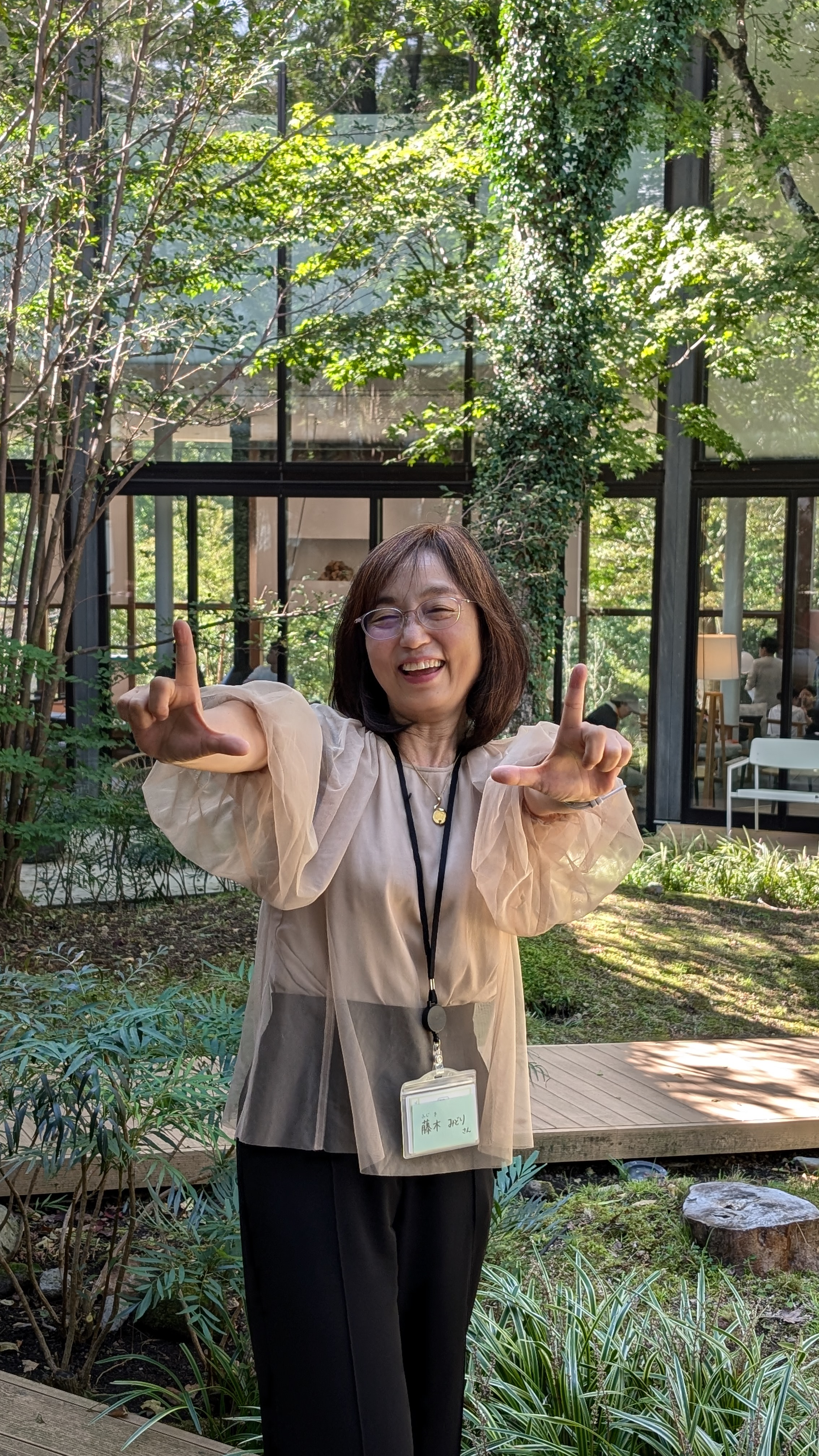 緑に囲まれた場所で笑顔を見せる藤木みどりさん